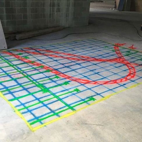 GPR mark-out grid in blue and green with a curved red line, painted on a concrete slab