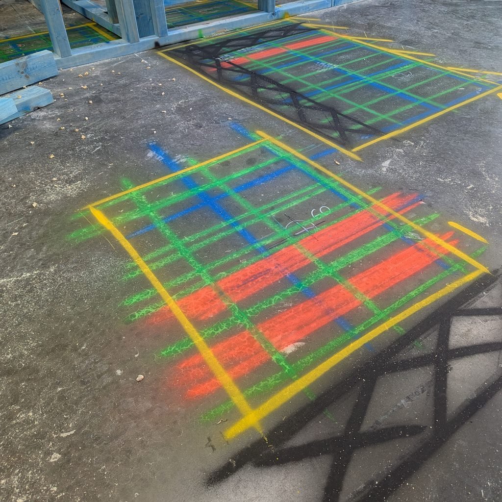 Two GPR scan grids spray-painted on a concrete slab beside timber wall framing