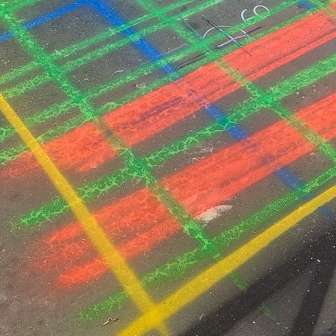 Close-up of orange bands and green grid lines marked on concrete after a GPR scan