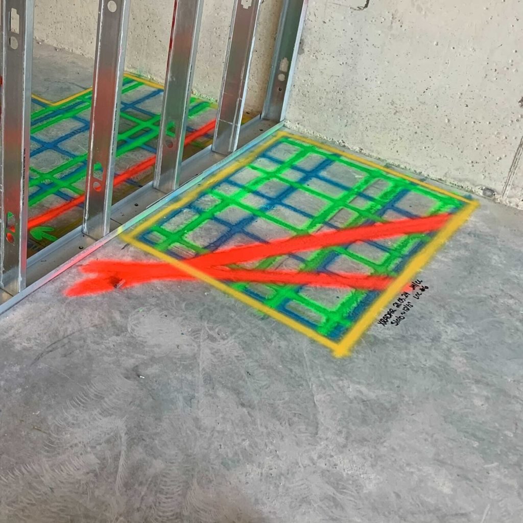 Scan grid with red lines marked on the floor beside steel wall studs