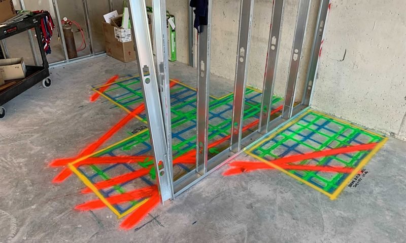 GPR mark-out in yellow, green, blue and red around steel studs on a concrete slab